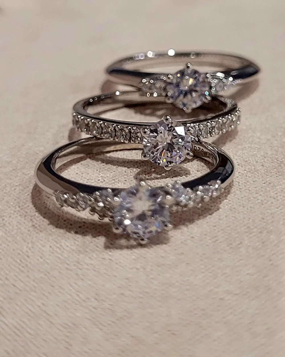 Drei Weißgoldringe mit Brillanten nebeneinander auf hellem Tuch