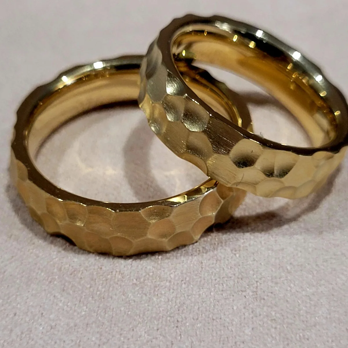Zwei breite Trauringe aus Gelbgold mit gehämmerter Oberfläche, in der Werkstatt von Hand gefertigt